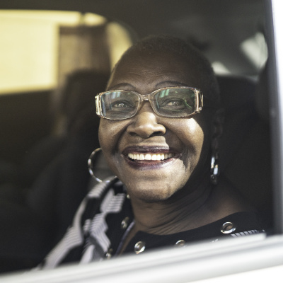 Older woman looking out car window while smiling